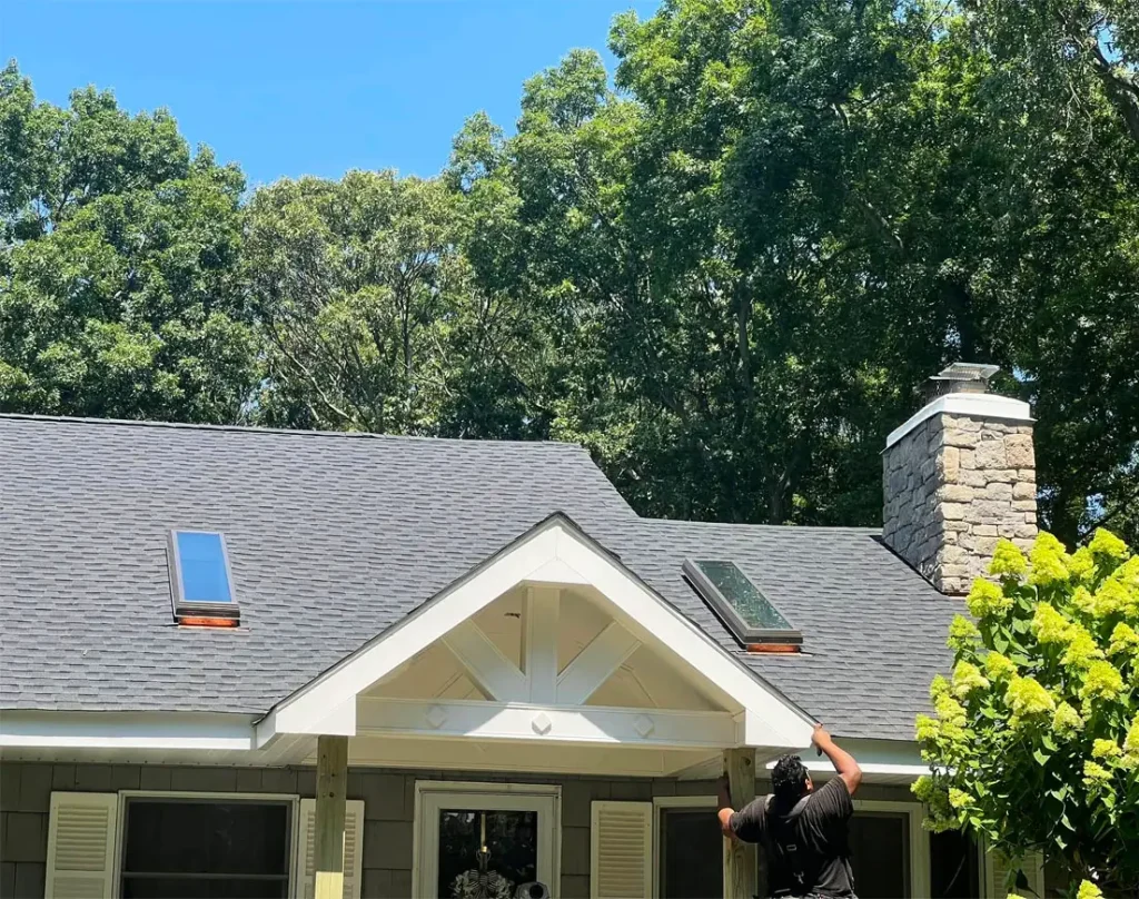 Man climbing off a single story home's roof just freshly installed.