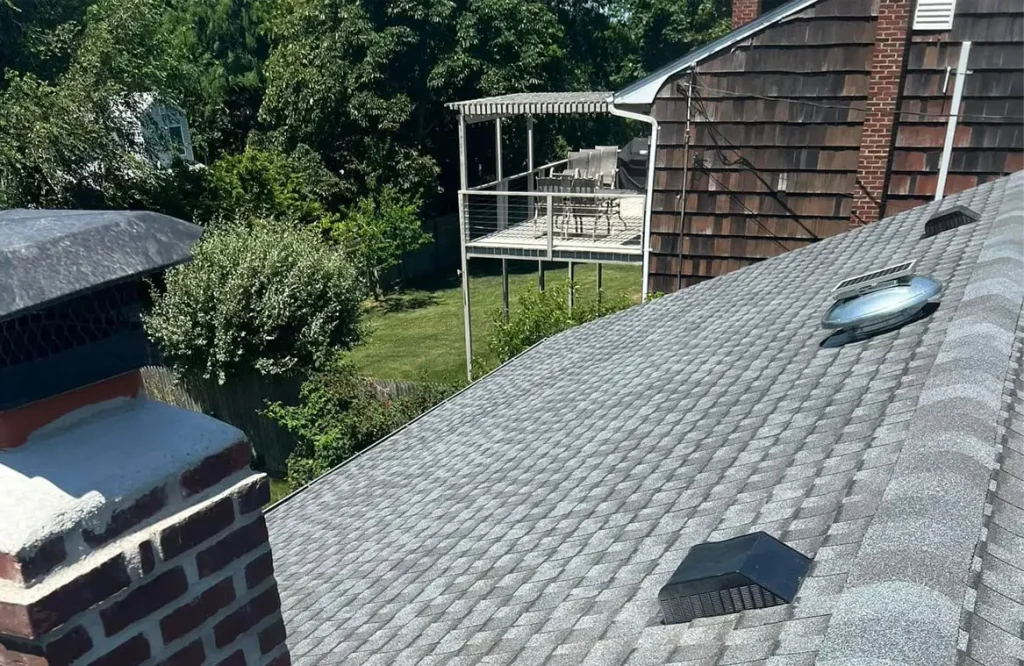 View from atop a single story home's rooftop and tile shingles.