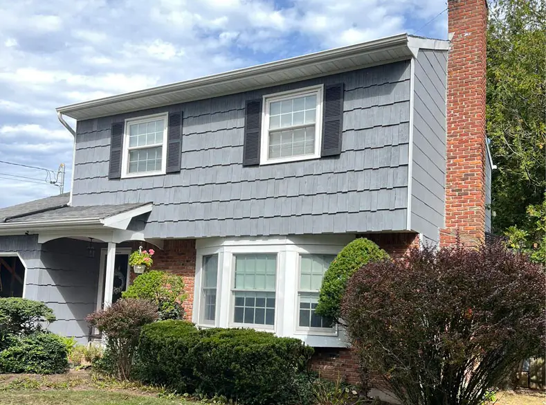 Two story home with wood siding painted gray.